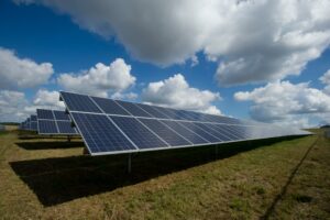 solar energy panels in a field with clouds